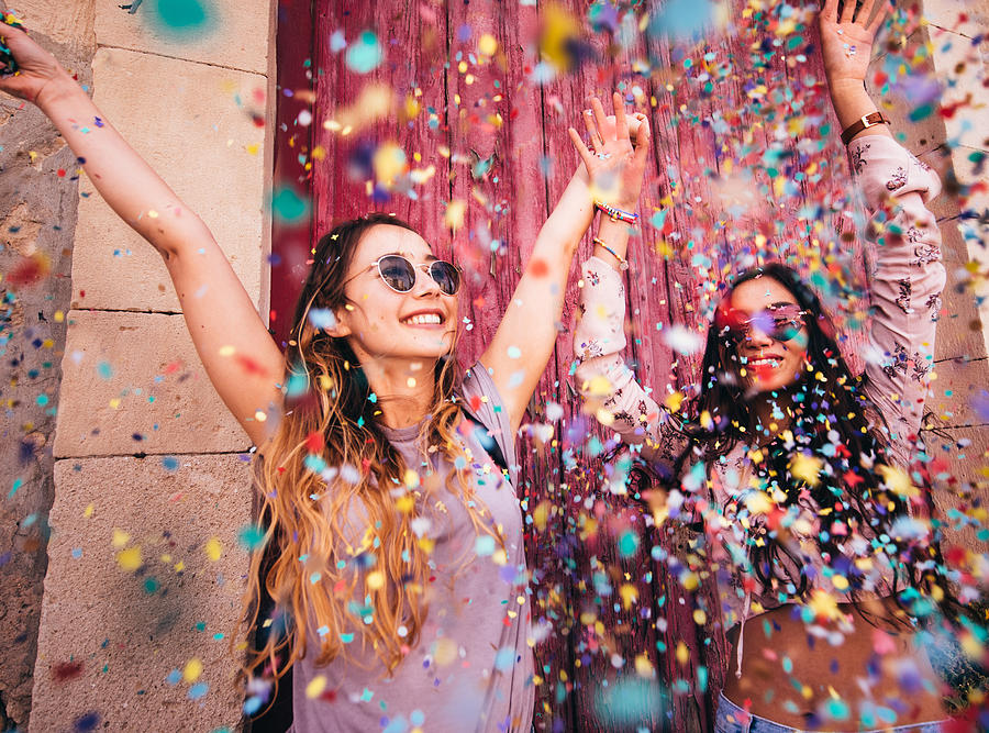 Young multi-ethnic hipster women celebrating with confetti in the city Photograph by Wundervisuals