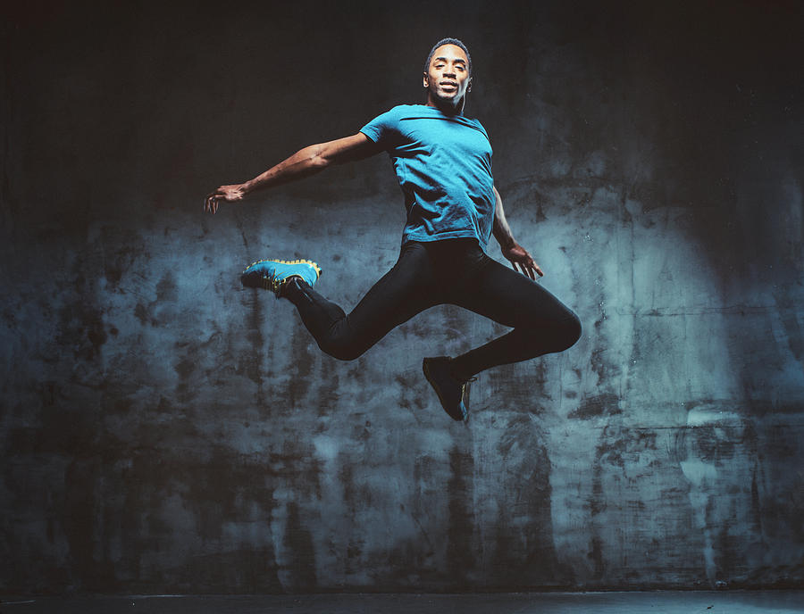 Young Muscular Man Jumping Photograph by StudioThreeDots