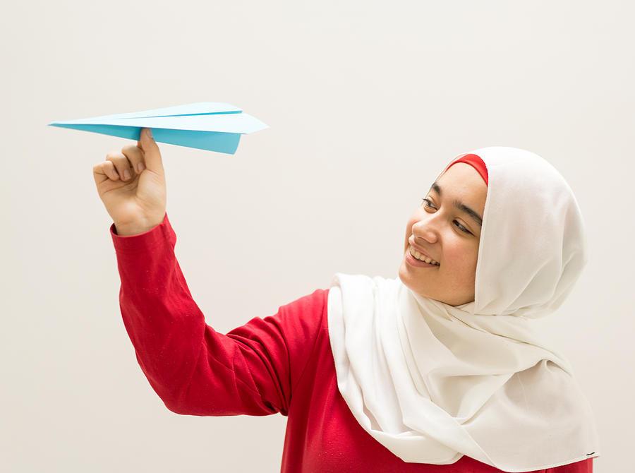 Young Muslim Girl Holding Paper Airplane Photograph by Jasmin Merdan
