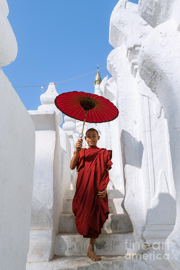 Young novice monk walking on white pagoda - Myanmar Photograph by Matteo Colombo