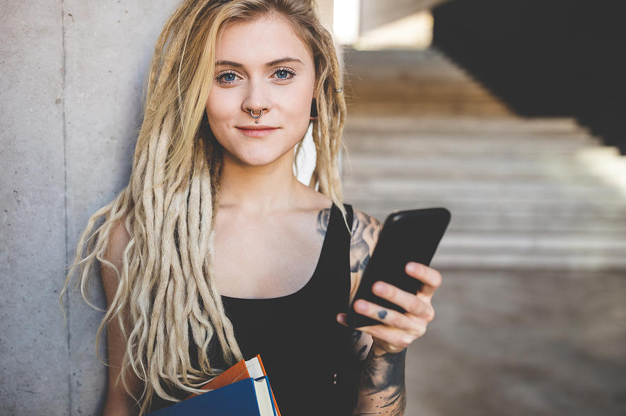 Young Tattooed Women Texting Message On Mobile Phone Photograph by Nikada