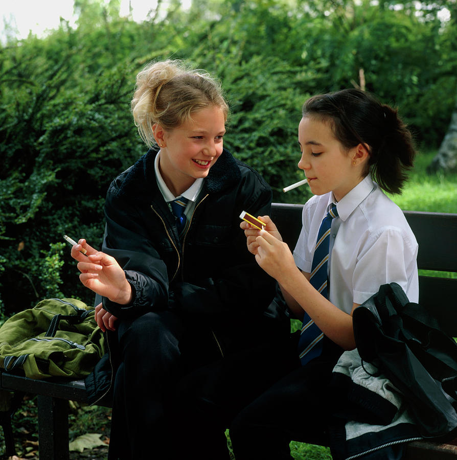 Young Teenage Girls Lighting Cigarettes Outdoors Photo