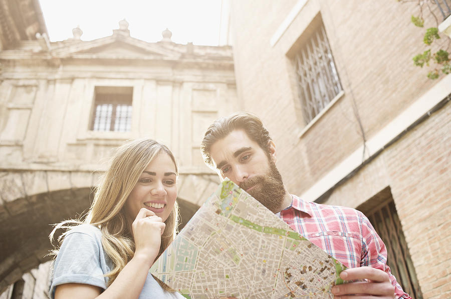 Young tourist couple looking at map outside Valencia Cathedral, Valencia, Spain Photograph by Andy Smith