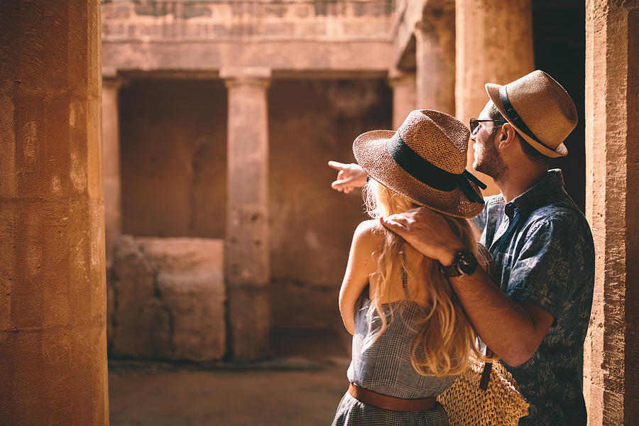 Young tourists couple doing sightseeing at ancient archaeological site Photograph by Wundervisuals