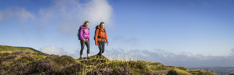 Young woman and teenage hiker walking picturesque summer mountain panorama Photograph by fotoVoyager