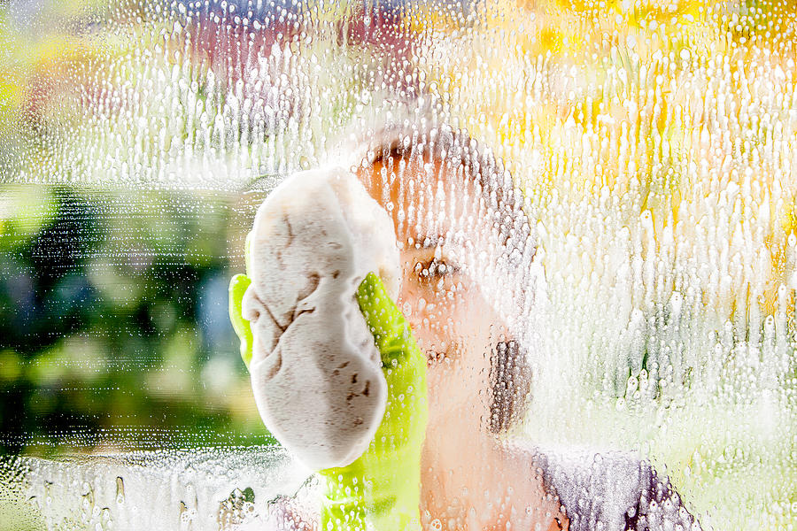 Young Woman Cleaning Windows Photograph by CasarsaGuru