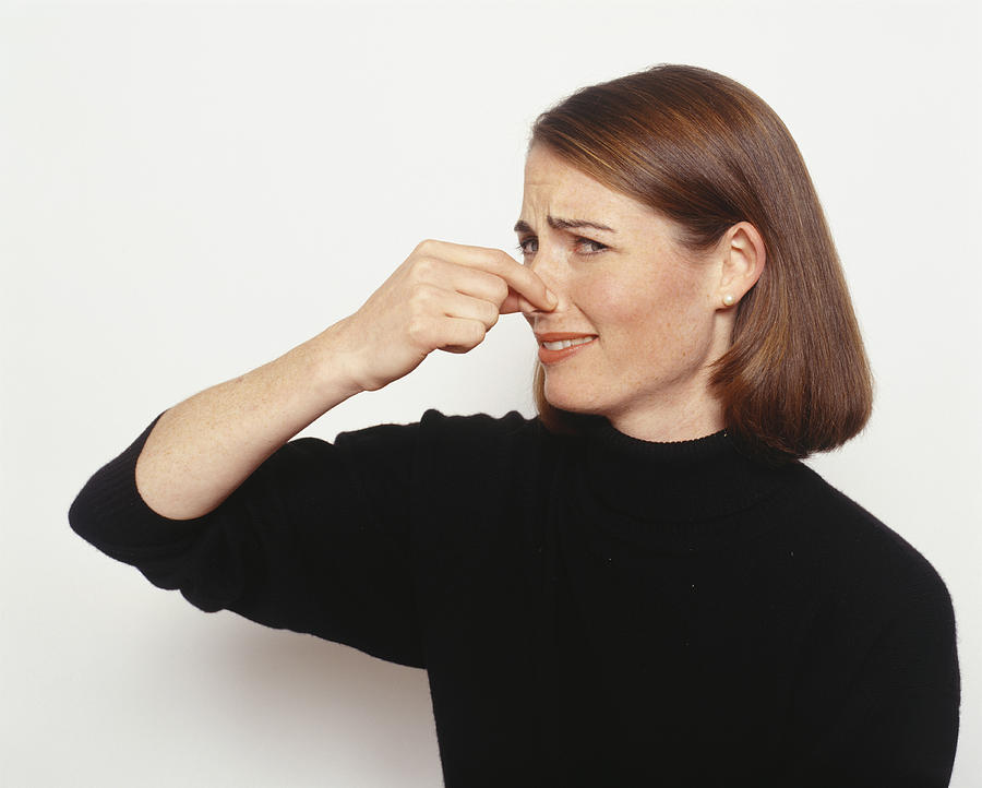 Young woman holding nose Photograph by Barbara Penoyar