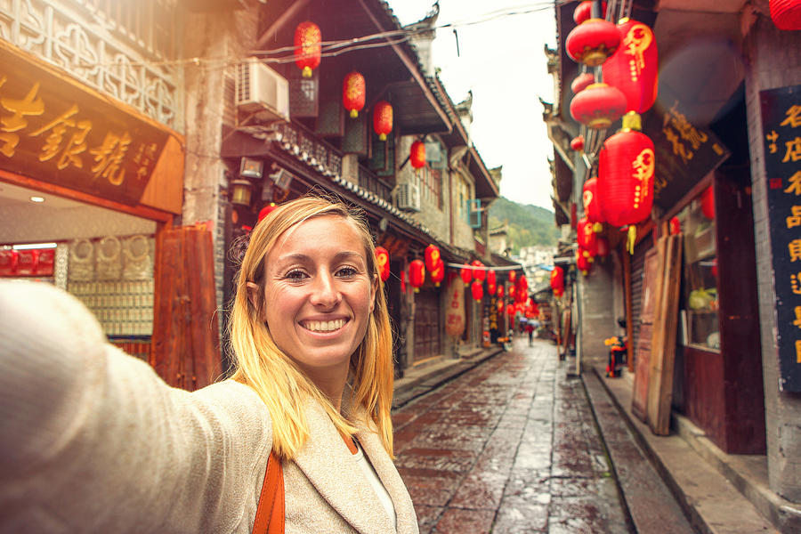 Young woman in Chinese street taking selfie portrait Photograph by Swissmediavision