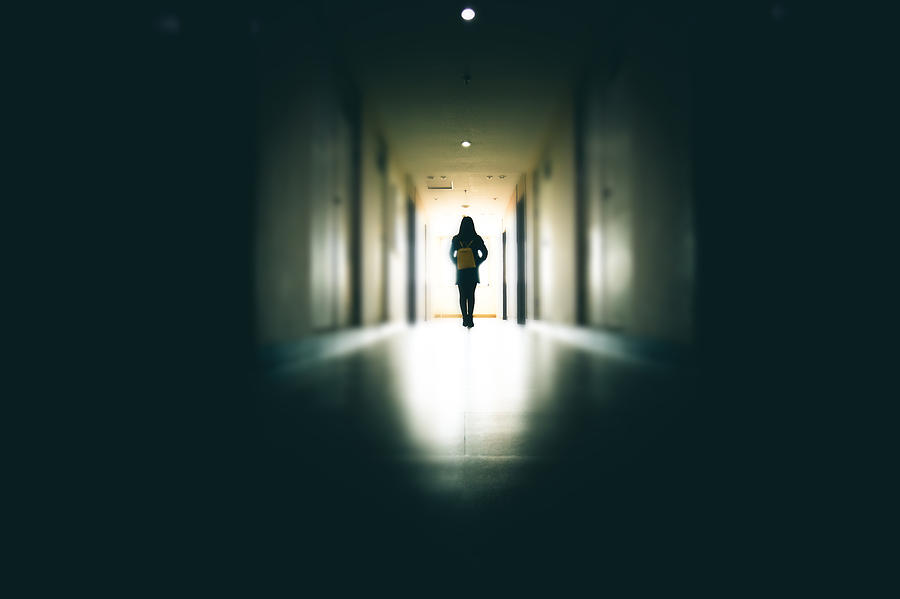 Young woman in dark building walkway Photograph by Xijian