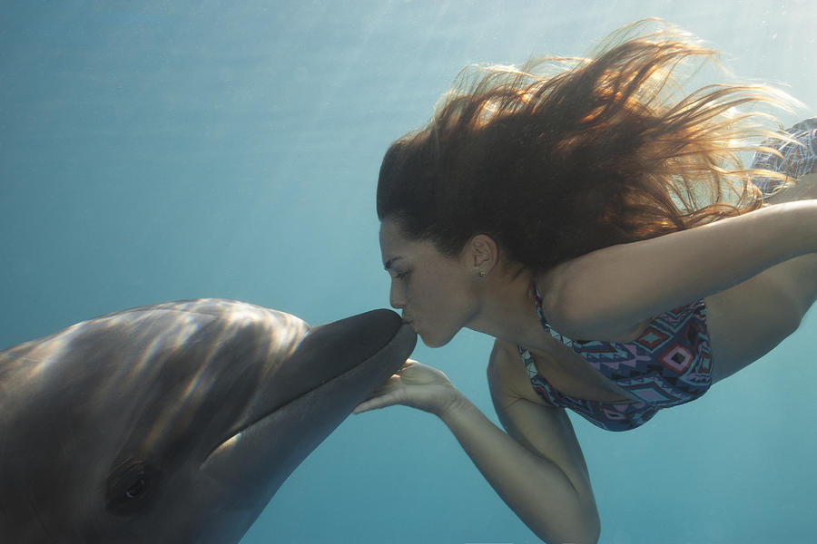 Young Woman Kisses Dolphin Underwater, Sunbeams Photograph by Justin Lewis