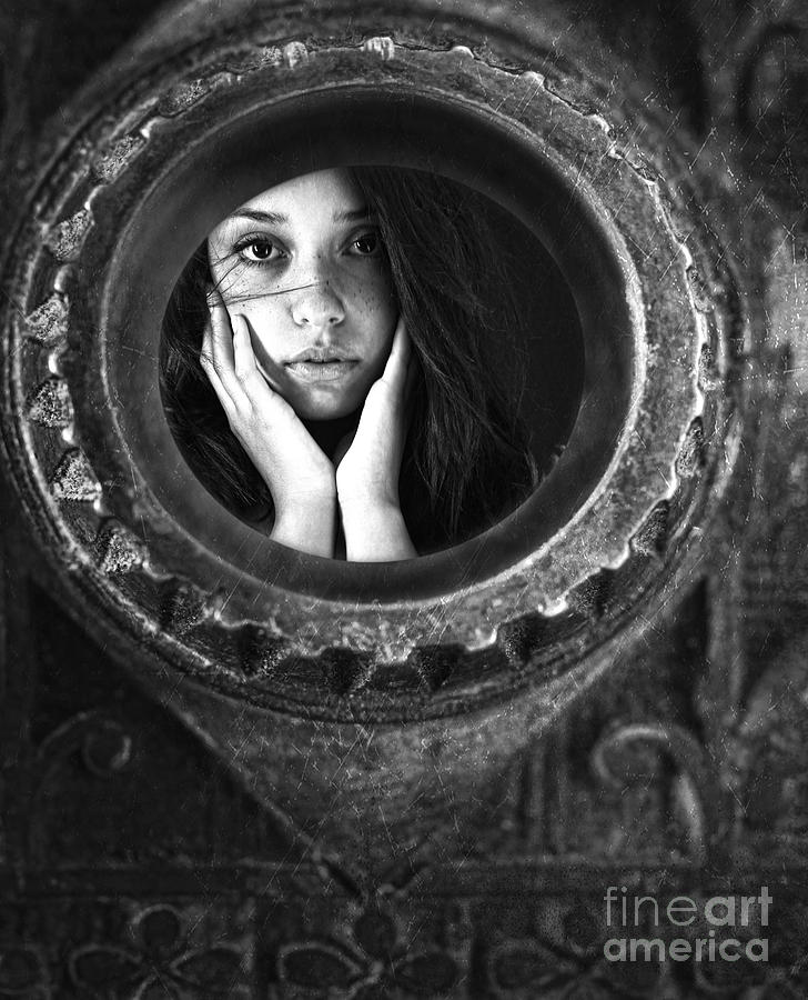 Young woman looking unsure and afraid looking through peep hole  Photograph by Sandra Cunningham