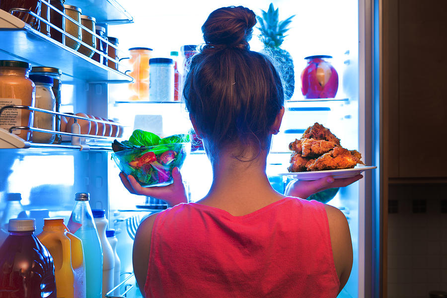 Young Woman Making Choices for a Healthy Salad or Junk Food Fried Chicken Photograph by YinYang