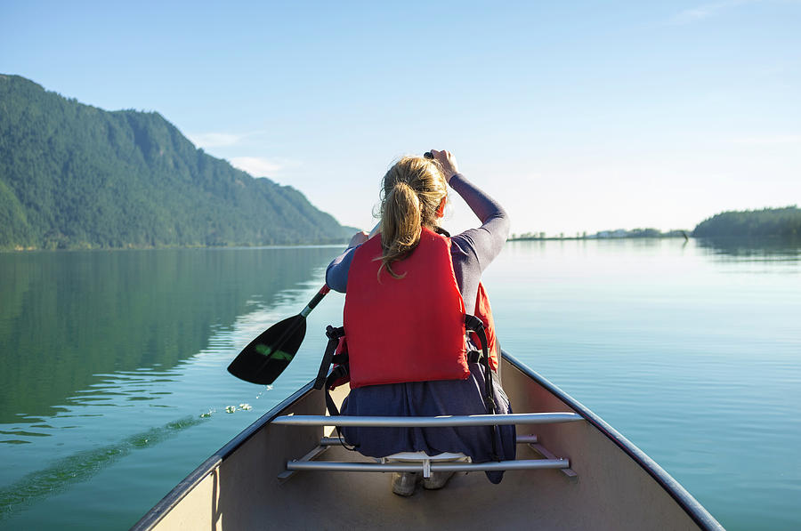 Young Woman Paddling A Canoe On A Lake Photograph by Laara Cerman/leigh Righton