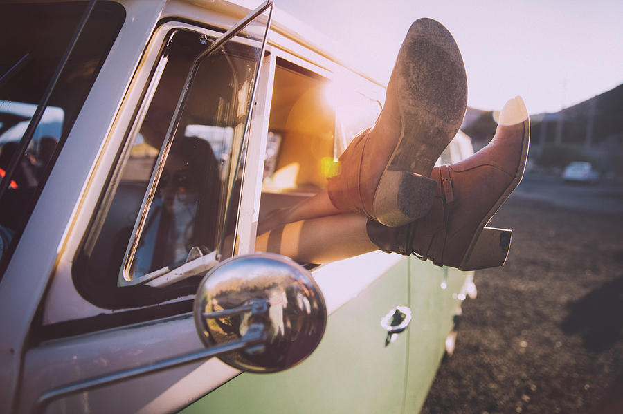 Young woman relaxing during a road trip with vintage van Photograph by Wundervisuals