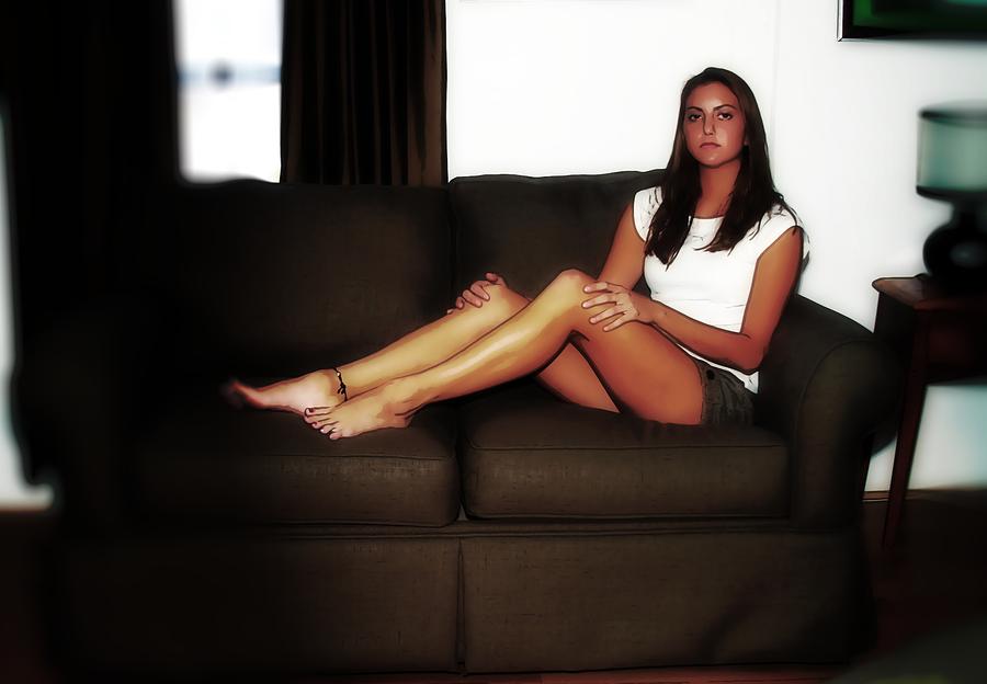 Portrait Photograph - Young woman sits on a couch. by Richard Hemingway