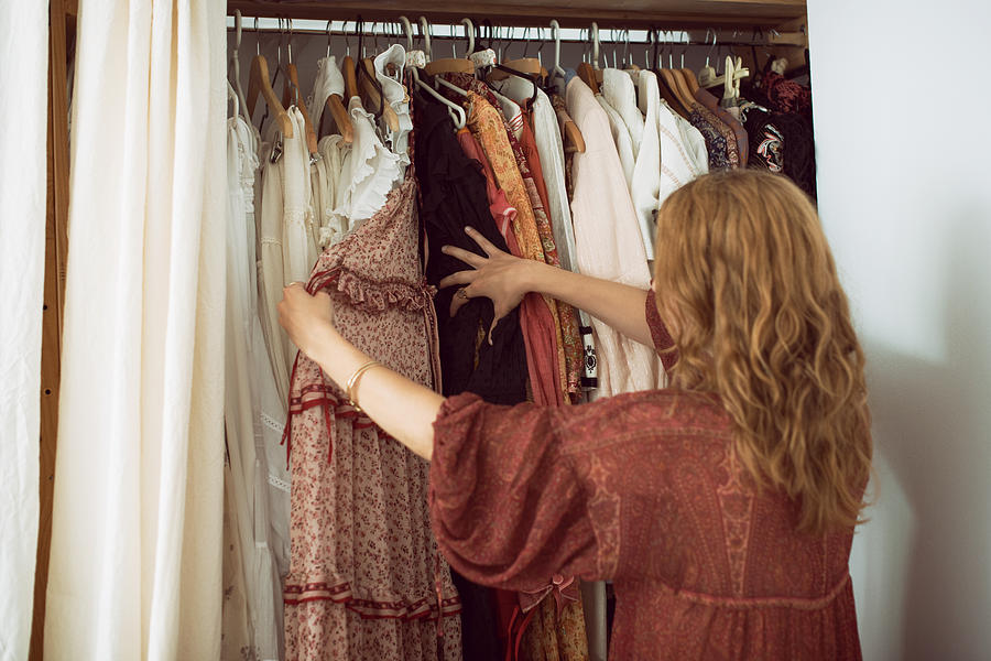 Young woman standing in front of her closet choosing something to wear Photograph by Emilija Manevska