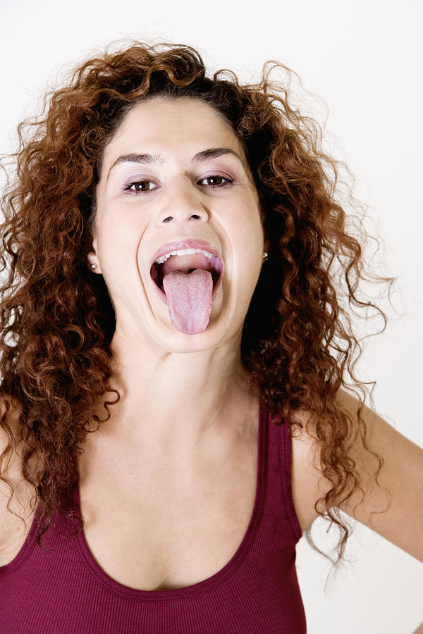 Young woman sticking out her tongue Photograph by Glowimages
