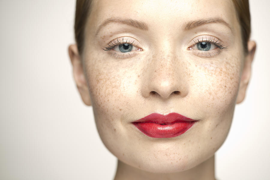 Young woman wearing bright red lipstick, portrait Photograph by PhotoAlto/Milena Boniek