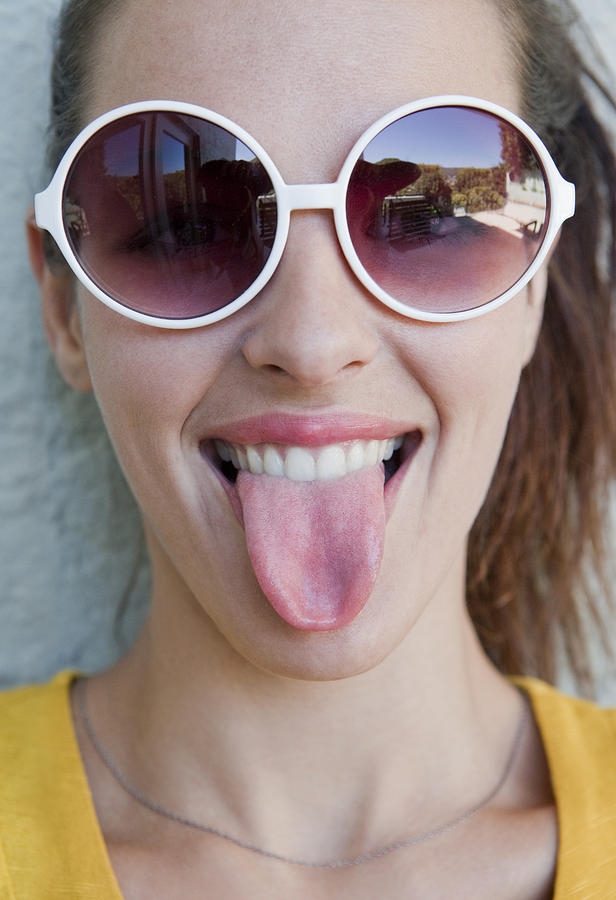 Young woman with sunglasses, showing her tongue Photograph by Dimitri Otis