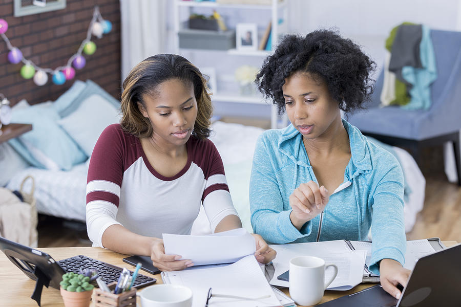 Young women work together on something in college dorm room Photograph by Steve Debenport Young women work together on something in college dorm room Photograph by Steve Debenport