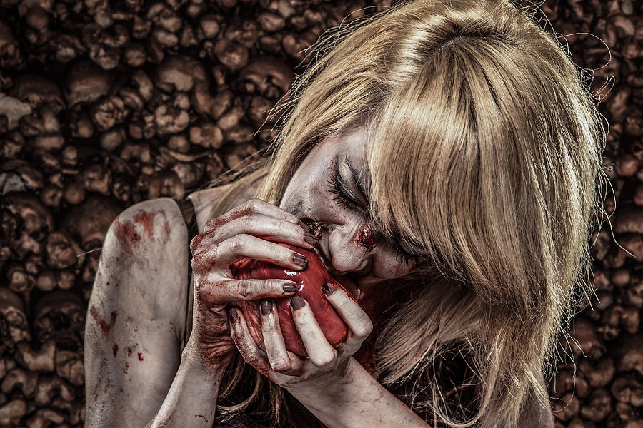 Young Zombie woman eating a Human Heart Photograph by Juhy13