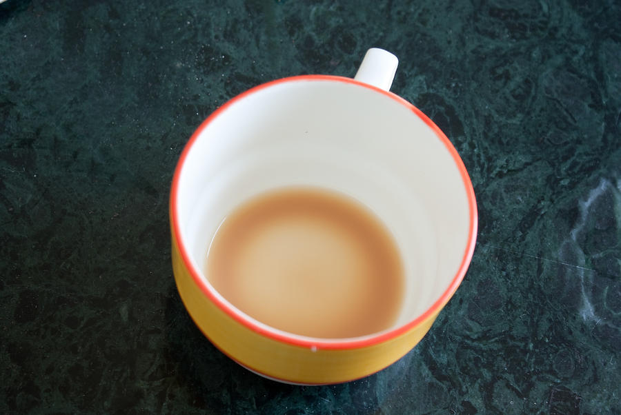 A cup with the remains of tea on a green table Photograph by Ashish Agarwal