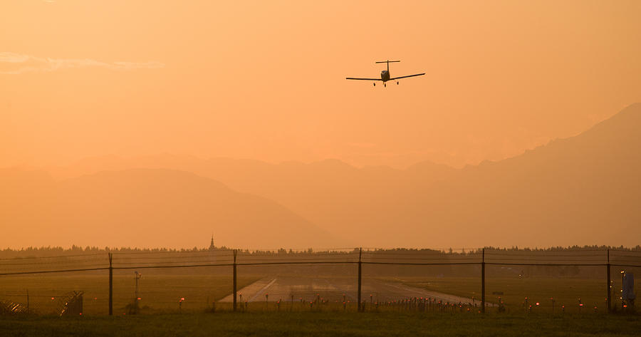 Light airplane landing at sunset on the summer solstice #1 Photograph by Ian Middleton