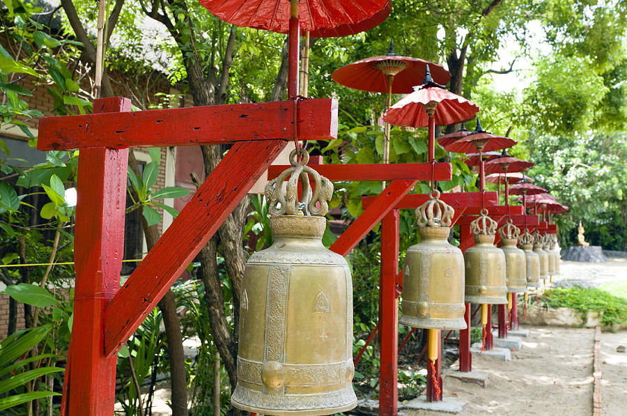 Row of bells in a temple covered by red umbrella #1 Photograph by U Schade