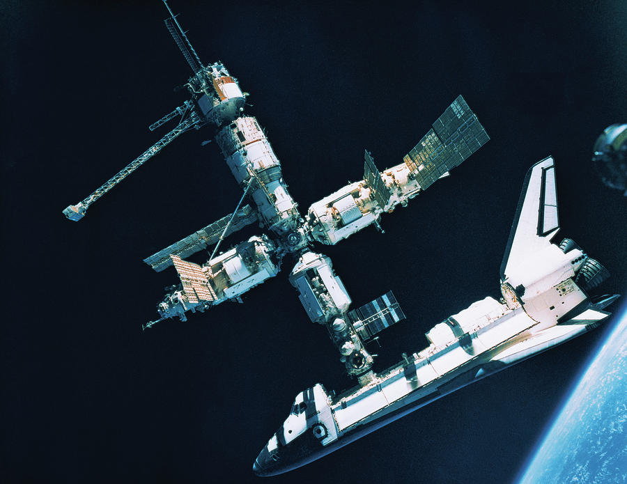 The Space Shuttle Docked With A Space Station #1 Photograph by Stockbyte