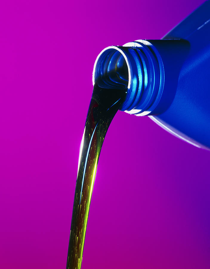 View Of Lubricating Oil Pouring From Its Bottle Photograph by Tek Image