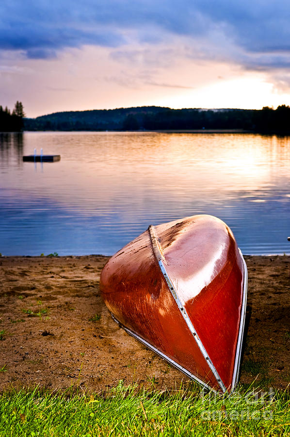 Lake sunset with canoe on beach 1 Photograph by Elena Elisseeva