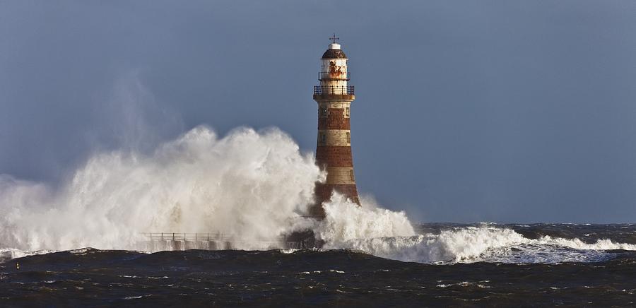 Waves Crashing Against A Lighthouse Photograph by John Short