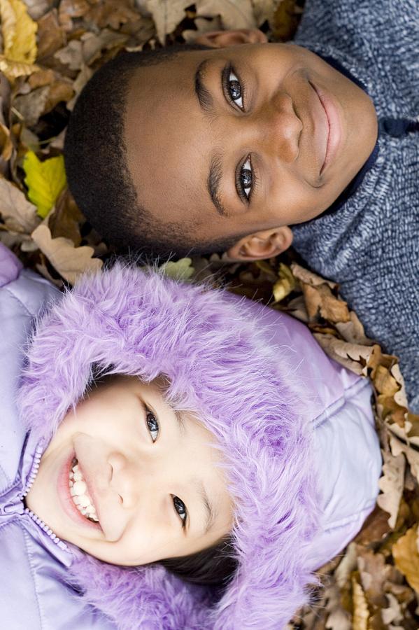 Fall Photograph - Smiling Children Lying On Autumn Leaves #6 by Ian Boddy