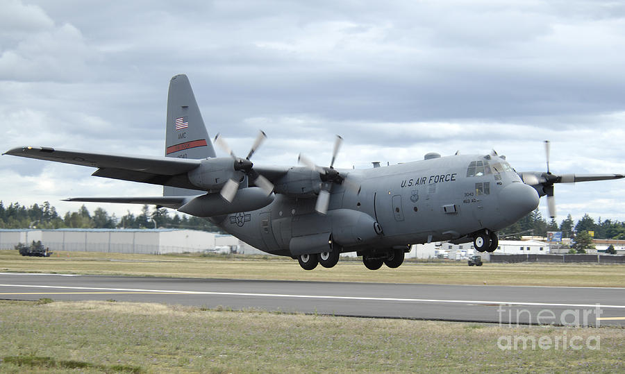 Transportation Photograph - A C-130 Hercules Lands At Mcchord Air by Stocktrek Images