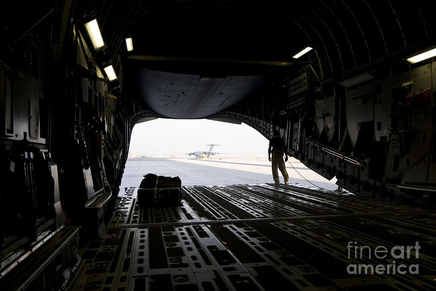 Airplane Photograph - A Loadmaster Guides The Pilot Of A C-17 by Terry Moore