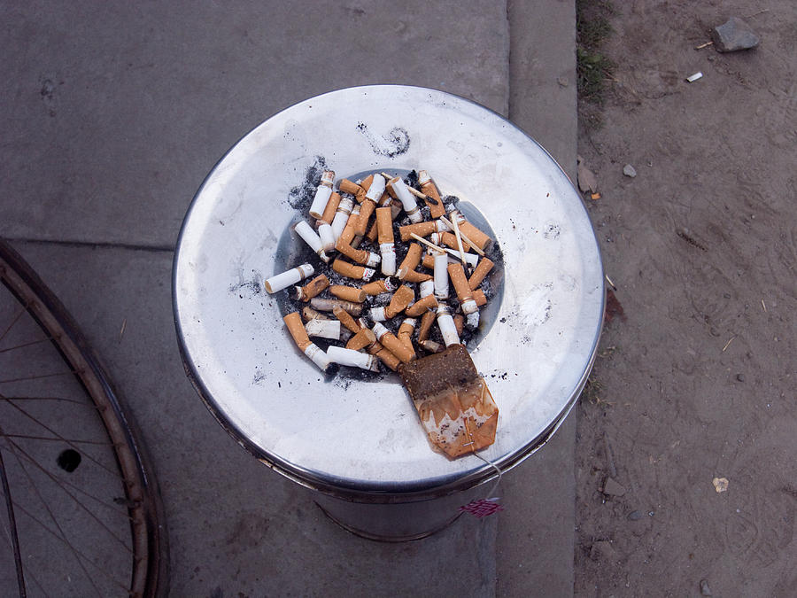 Stubs Photograph - A lot of cigarettes stubbed out at a garbage bin by Ashish Agarwal