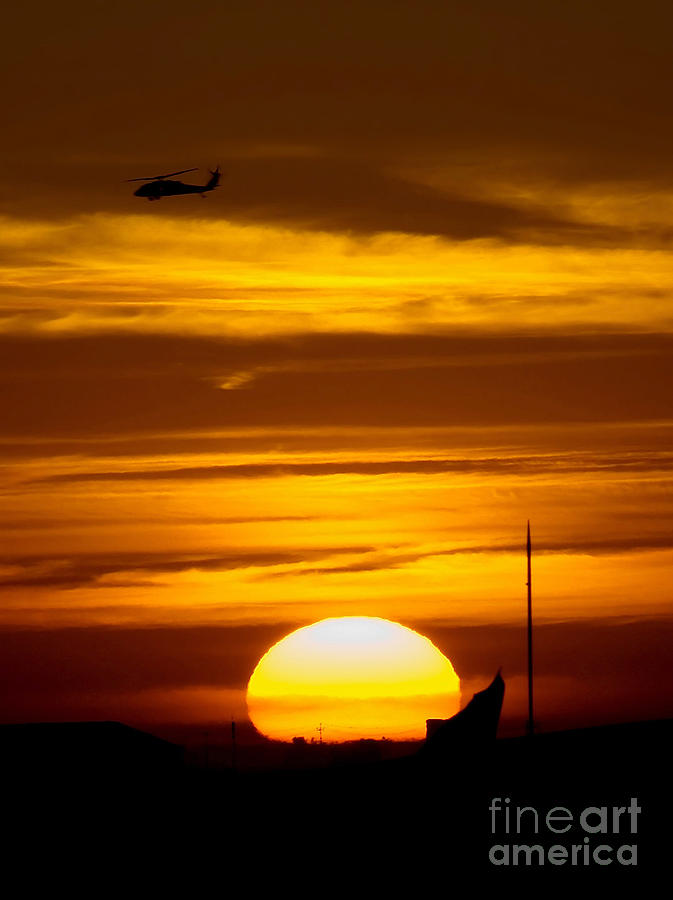 Sunset Photograph - A Uh-60 Black Hawk Helicopter Flies by Stocktrek Images