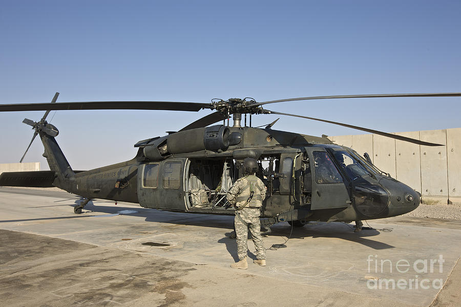 A U.s. Army Crew Chief Stands Next Photograph by Terry Moore - Fine Art ...