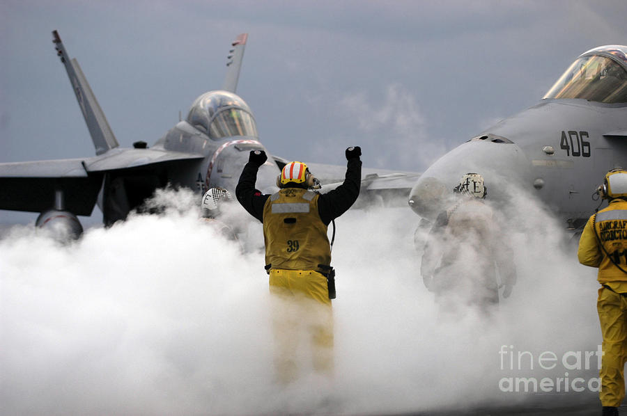 Airplane Photograph - An Airman Directs An Fa-18c Hornet Onto by Stocktrek Images