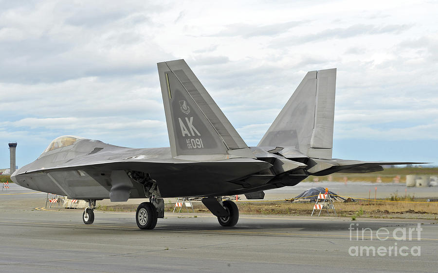 Transportation Photograph - An F-22 Raptor Taxis The Runway by Stocktrek Images