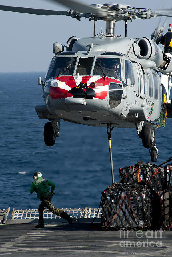 Transportation Photograph - An Mh-60s Sea Hawk Picks Up Pallets by Stocktrek Images