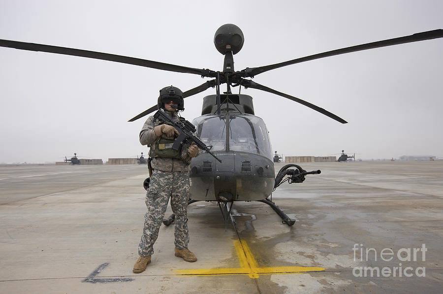 Helicopter Photograph - An Oh-58d Kiowa Warrior Pilot Stands by Terry Moore