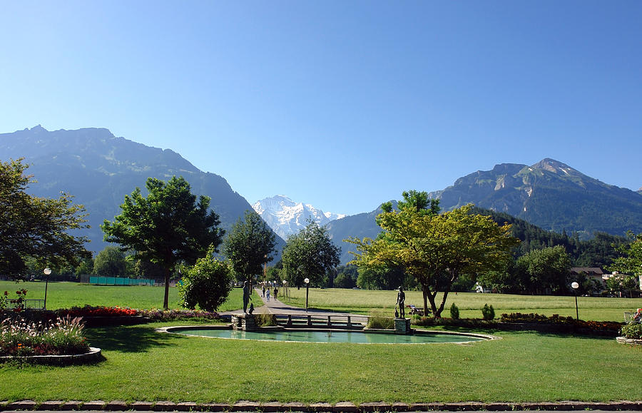 An open field in Interlaken with a view of the mountains in the background Photograph by Ashish Agarwal