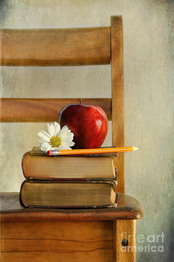 Apple and books on old school chair Photograph by Sandra Cunningham