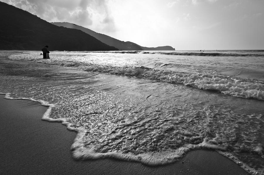 Black and white image of waves rolling onto a beach ...