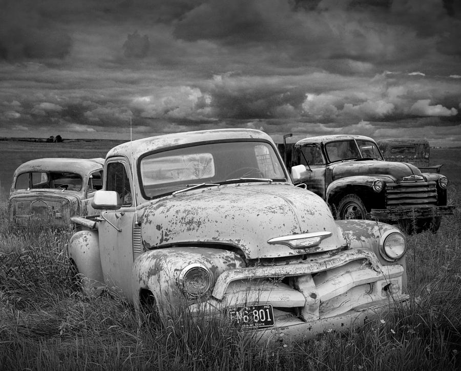 Vintage Photograph - Black and white Photograph of a Junk Yard with Vintage Auto Bodies by Randall Nyhof