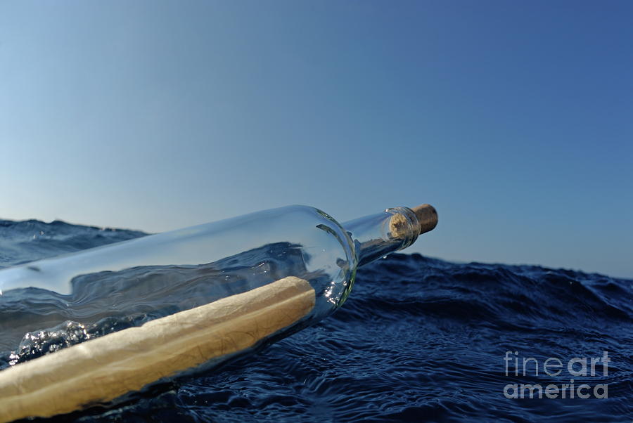 Bottle containing message floating in sea Photograph by Sami Sarkis