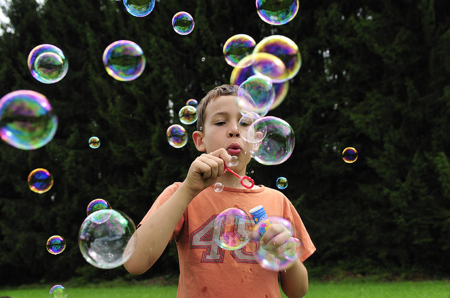 Boy with colorful bubbles Photograph by Matthias Hauser