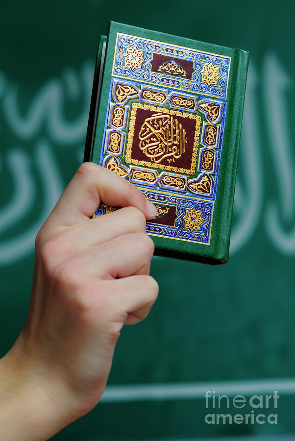 Flag Photograph - Boys hand holding Koran by Sami Sarkis