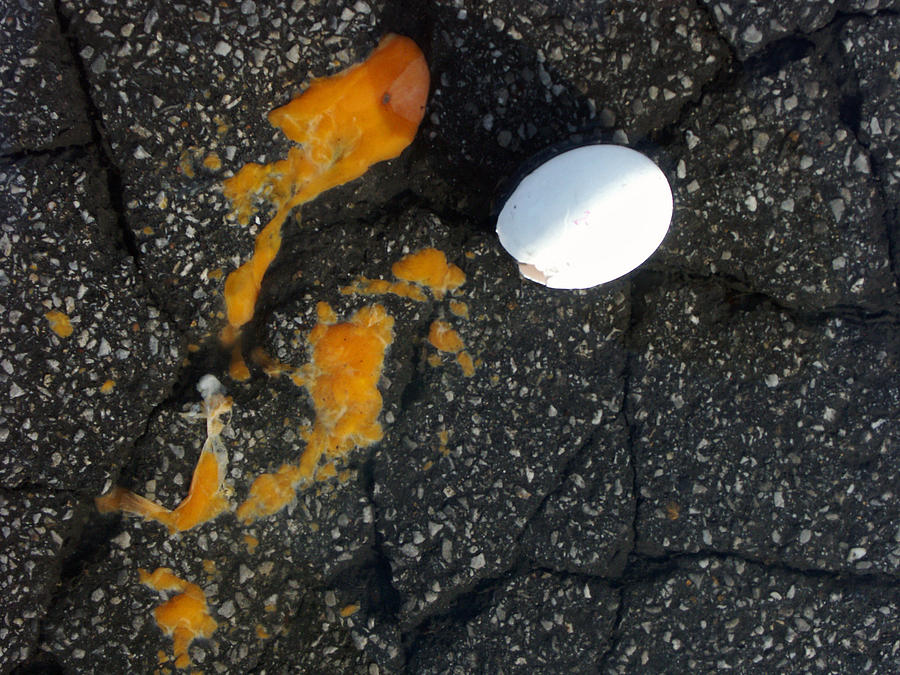 Broken white egg and orange yolk on black ground Photograph by Matthias Hauser